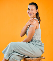Woman, portrait and smile in studio background with plaster for vaccination and protection in...
