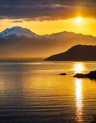 Fototapeta premium Golden Sunset Reflecting Over Calm Ocean Waters, Captured Against the Silhouette of Distant Mountains and Snow-Capped Peaks for a Serene Coastal Landscape Scene