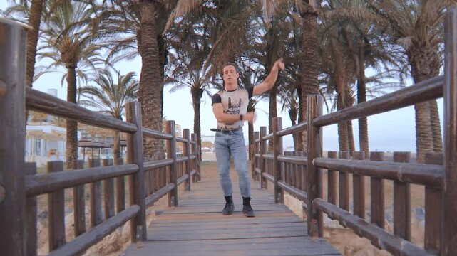 Modern Funk Dancer on a Wooden Bridge with Palm Trees in the Background. Bailar&iacute;n de Funk Moderno en un Puente de Madera con Palmeras de Fondo