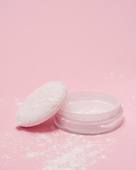 Cosmetic cream and powder on pink background.