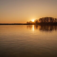Obraz premium Serene Sunset Over Calm Lake with Silhouetted Trees and Warm Orange Sky Reflection 