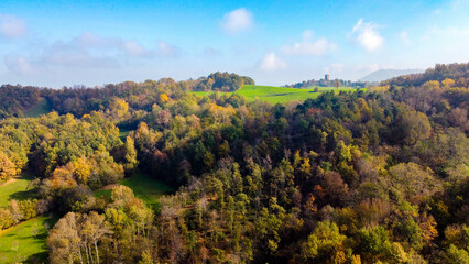 Vista aerea dei coloratissimi boschi e prati dell'Appennino modenese durante una soleggiata giornata d'autunno