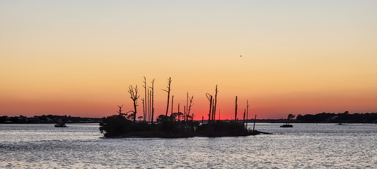 Obraz premium October Orange Sunset over a barrier island by the Intracoastal Waterway in Perdido Key, Florida