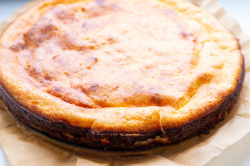 A slice of cake with a brown crust and a golden center. The cake is sitting on a piece of parchment paper