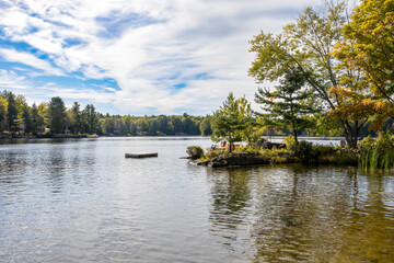 The serene beauty of Bala, Ontario with its flowing river, lush trees, and a tranquil cottage setting.