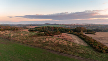 Krak&oacute;w-Częstochowa Upland, autumn fields sown with catch crops, just before sunset, full of autumn golden hues and colors, top view from a drone.