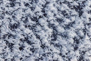 Big fluffy snowflakes on the surface of the ice. Winter and Christmas background