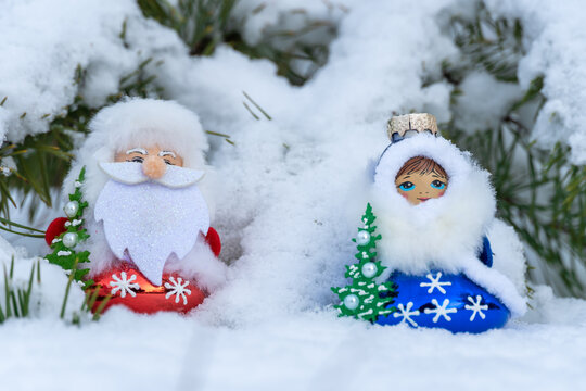 Santa claus and snow maiden in christmas clothes stand under pine branch tree with white snow in winter forest. Snegurochka and ded moroz new year bauble. Snow woman and father frost  of winter xmas.