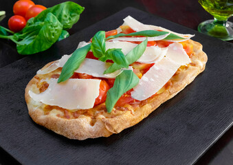 Pinsa Romana with Cheese Shavings, Cherry Tomatoes, and Fresh Basil