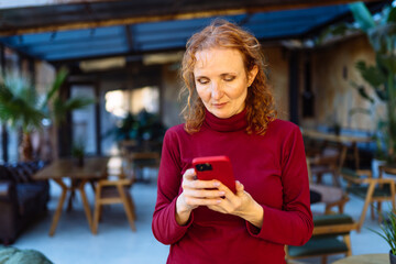 Woman using smartphone in outdoor cafe setting