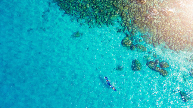 Beach, drone and people on paddle board for holiday adventure, water sports and outdoor fun. Nature, calm ocean and aerial view of couple on surf for travel, summer vacation and tropical island coast