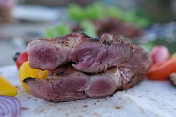 Grilled sliced meat. chef turns over grilled beef steaks in a restaurant. Using tongs to cook meat on grill. Professional bbq cooking delicious.
