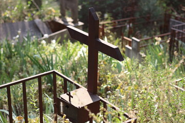 Rest in Bloom: Grave Cross Amid Lush Foliage and Flowers