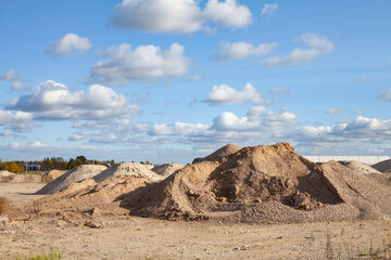 Preparation for the start of a large construction project, piles of sand and gravel on a leveled field