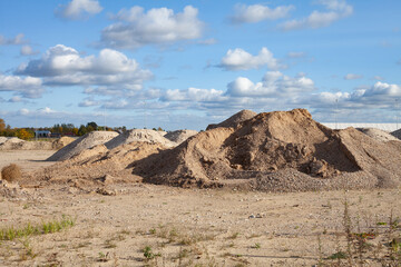 Preparation for the start of a large construction project, piles of sand and gravel on a leveled field