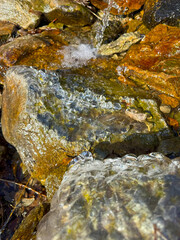 A natural spring along the hiking trail to Mount Giewont in the Tatra Mountains, Poland, offering a refreshing water source for hikers