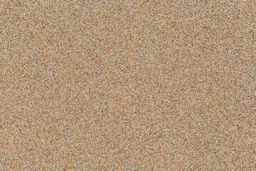 Smooth untouched fine sand on a beach on a sunny day, viewed from above. Abstract textured natural sandy background, top view. Copy space.