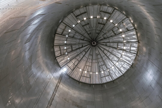 Indoors view of silo grain bin with conical roof. View from bottom to top.