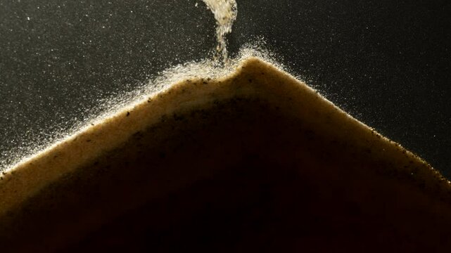Sand particles falling down in abstract slow motion. Macro shot. 