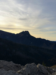 Mount Giewont with a cross at its summit during sunset, Tatra Mountains, Poland, capturing the beauty of the mountain silhouette against a colorful sky