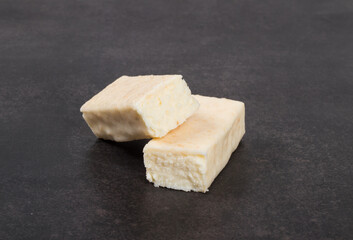 Cottage cheese coconut  bar in white chocolate glaze. Dark background. Close-up	