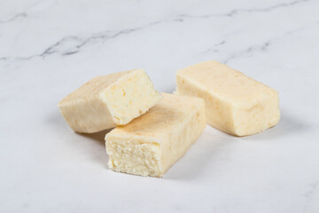 Cottage cheese coconut  bar in white chocolate glaze. White background. Close-up	