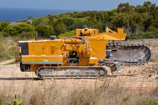 Powerful Trencher Machine on a Coastal Landscape, with sea View on backgtound 