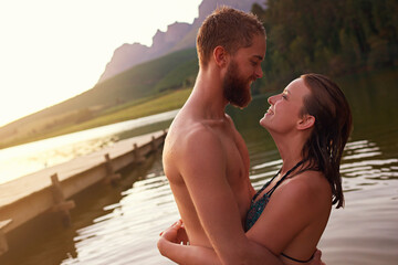 Fototapeta premium Couple, hug and swimming in lake on vacation with affection, relationship and happy for summer adventure. People, embrace and smile in river at countryside for romantic holiday and bonding together