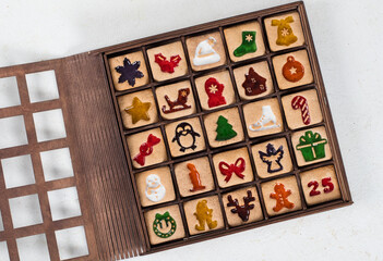 25 Holiday square cookies in the shape of a Christmas Advent Calendar. In a wooden gift box. Top...