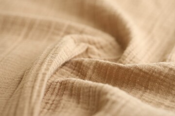 Texture of crumpled linen fabric under natural light in peach fuzz color
