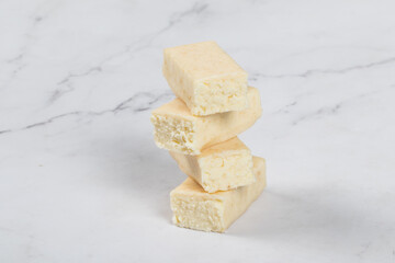 Cottage cheese coconut bar in white chocolate. White background. Close-up	