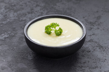 Vegan Potato soup puree in a bowl. With parsley. Close-up. Dark background