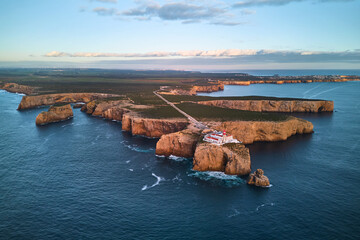 The lighthouse of Cabo de São Vicente and fort ruins at sunset. Aerial view from the ocean