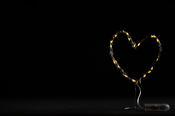 estructura de alambre forrada de luces en forma de corazón con fondo negro