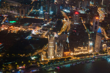 Fototapeta premium Aerial view of Shanghai at night, featuring the illuminated Bund, modern skyscrapers, and traditional architecture of the old town along the Huangpu River.