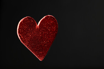Un corazón rojo con  textura aislado con fondo negro y espacio para texto
