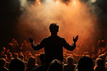 silhouette of a man from the back coming out from behind the scenes onto the stage