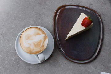 close up coffee and cheesecake on grey table. top view