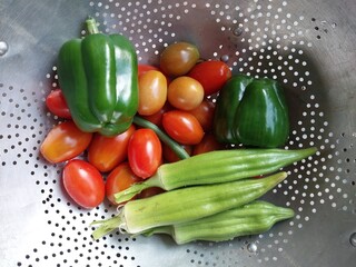 fresh summer vegetables vintage colander green bell peppers tomatoes okra