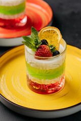 Layered fruit parfaits with berries and mint, elegantly served on colorful plates 