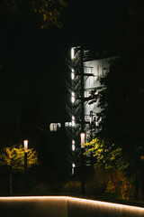 Beleuchtete Feuertreppe an Gebäude bei Nacht