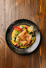 Top view of a gourmet salad with smoked salmon, vibrant greens, and artistic garnishes on table