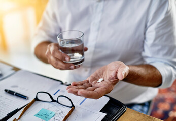 Businessman, drinking water and hands with pills for medicine dosage, painkillers or medication. Migraine, paperwork or financial advisor with tablets, glass or closeup for headache and supplements