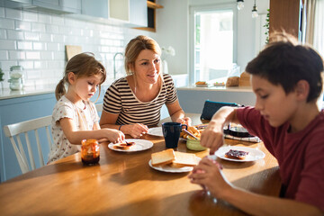 Mother and children enjoying breakfast together in kitchen