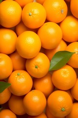 A close-up shot of a pile of fresh oranges with green leaves.