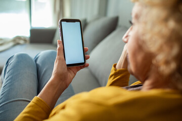 Woman relaxing on couch using smartphone at home