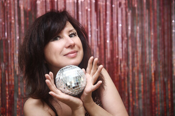 Young pretty woman with a shining disco ball