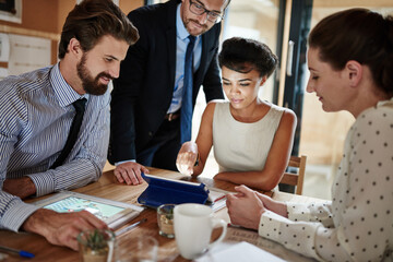 Teamwork, tablet and business people in meeting, planning and research for stock market. Economy analyst, group and employees with tech, online news for investments and update company website