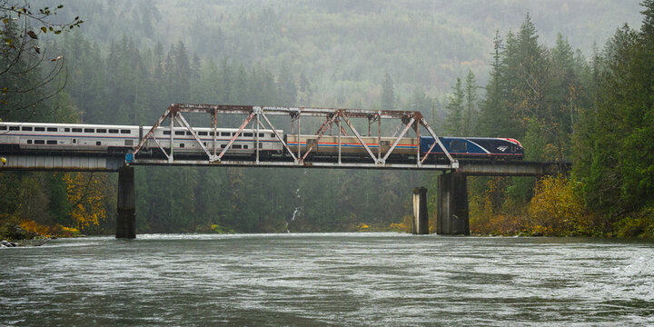 Gold Bar, WA, USA - October 28, 2024; Amtrak Empire Builder Chicago to Seattle train crosses Big Eddy in pouring rain