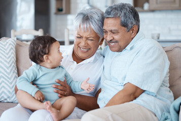 Obraz premium Relax, love and grandparents with baby on sofa for bonding, laughing and support. Smile, happiness and generations with senior man and woman holding child in living room of family home together